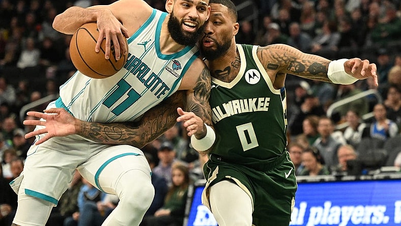 Feb 9, 2024; Milwaukee, Wisconsin, USA; Charlotte Hornets forward Cody Martin (11) drives to the basket against Milwaukee Bucks guard Damian Lillard (0) in the first half at Fiserv Forum. Mandatory Credit: Michael McLoone-USA TODAY Sports
