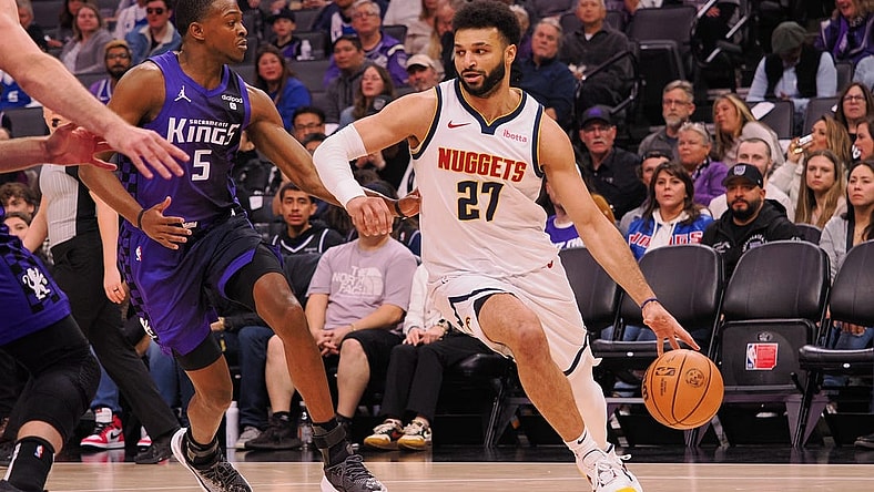 Feb 9, 2024; Sacramento, California, USA; Denver Nuggets guard Jamal Murray (27) controls the ball against Sacramento Kings guard De'Aaron Fox (5) during the first quarter at Golden 1 Center. Mandatory Credit: Kelley L Cox-USA TODAY Sports