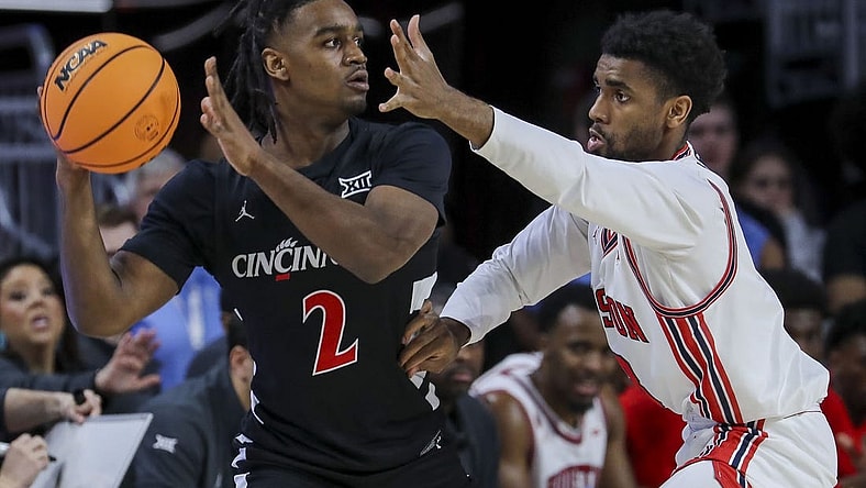 Feb 10, 2024; Cincinnati, Ohio, USA; Cincinnati Bearcats guard Jizzle James (2) holds the ball against Houston Cougars guard Mylik Wilson (8) in the first half at Fifth Third Arena. Mandatory Credit: Katie Stratman-USA TODAY Sports