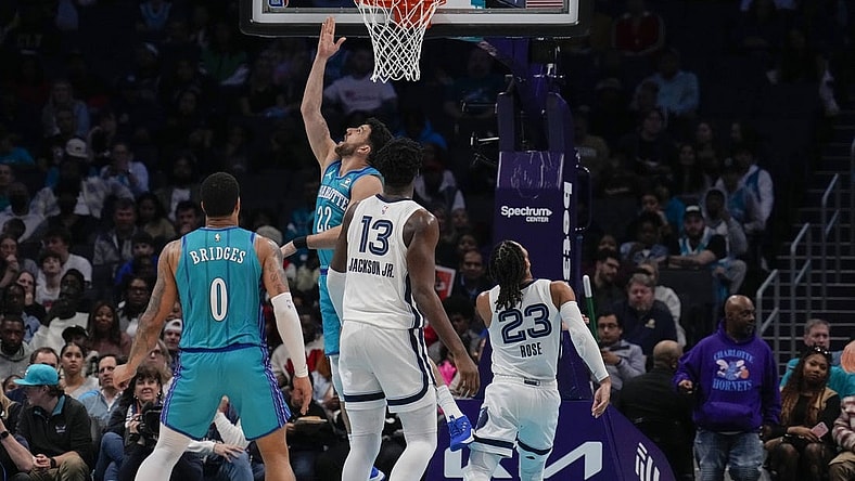 Feb 10, 2024; Charlotte, North Carolina, USA; Charlotte Hornets guard Vasilije Micic (22) with a reverse layup defended by Memphis Grizzlies guard Derrick Rose (23) during the second half at Spectrum Center. Mandatory Credit: Jim Dedmon-USA TODAY Sports