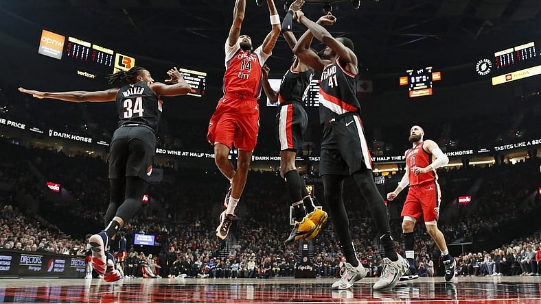 Feb 10, 2024; Portland, Oregon, USA; New Orleans Pelicans small forward Brandon Ingram (14) drives for the basket between Portland Trail Blazers forward Jabari Walker (34) and small forward Jerami Grant (9, right) during the first half at Moda Center. Mandatory Credit: Soobum Im-USA TODAY Sports