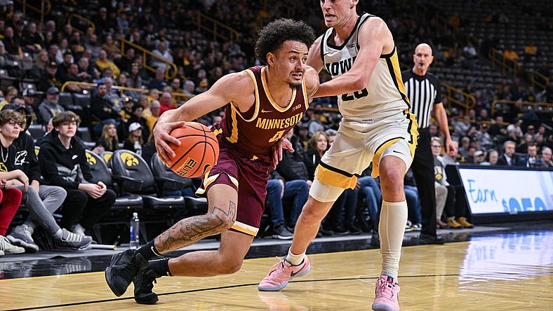 Feb 11, 2024; Iowa City, Iowa, USA; Minnesota Golden Gophers guard Braeden Carrington (4) goes to the basket as Iowa Hawkeyes forward Payton Sandfort (20) defends during the first half at Carver-Hawkeye Arena. Mandatory Credit: Jeffrey Becker-USA TODAY Sports