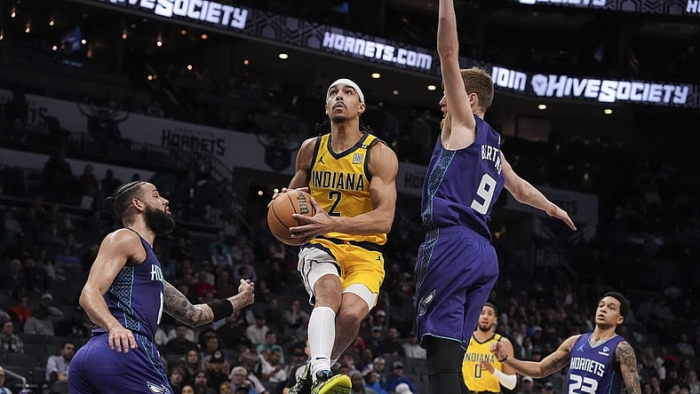 Feb 12, 2024; Charlotte, North Carolina, USA; Indiana Pacers guard Andrew Nembhard (2) goes up for a layup defended but Charlotte Hornets forward Davis Bertans (9) during the second quarter at Spectrum Center. Mandatory Credit: Jim Dedmon-USA TODAY Sports