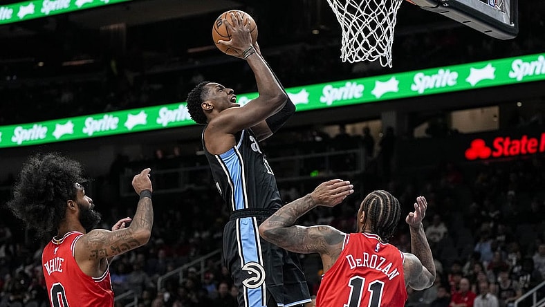 Feb 12, 2024; Atlanta, Georgia, USA; Atlanta Hawks forward Onyeka Okongwu (17) scores a basket over Chicago Bulls forward DeMar DeRozan (11) during the first half at State Farm Arena. Mandatory Credit: Dale Zanine-USA TODAY Sports