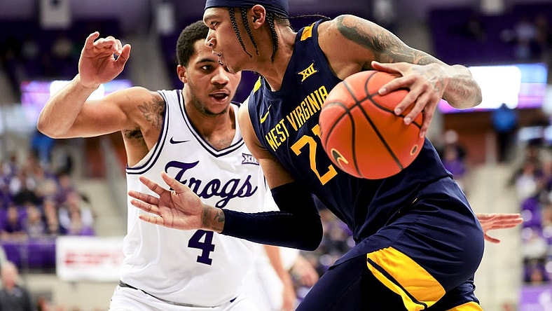 Feb 12, 2024; Fort Worth, Texas, USA;  West Virginia Mountaineers guard RaeQuan Battle (21) drives to the basket as TCU Horned Frogs guard Jameer Nelson Jr. (4) defends during the second half at Ed and Rae Schollmaier Arena. Mandatory Credit: Kevin Jairaj-USA TODAY Sports