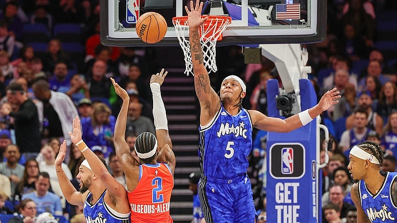 Feb 13, 2024; Orlando, Florida, USA; Oklahoma City Thunder guard Shai Gilgeous-Alexander (2) shoots the ball over Orlando Magic forward Paolo Banchero (5) during the first quarter at Amway Center. Mandatory Credit: Mike Watters-USA TODAY Sports