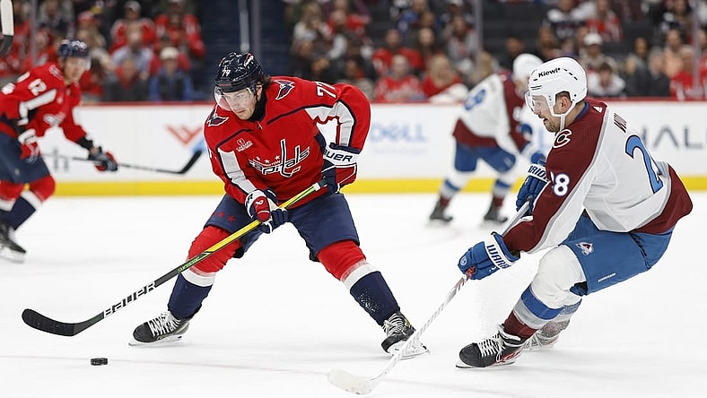 Feb 13, 2024; Washington, District of Columbia, USA; Washington Capitals right wing T.J. Oshie (77) controls the puck as Colorado Avalanche left wing Miles Wood (28) defends in the second period at Capital One Arena. Mandatory Credit: Geoff Burke-USA TODAY Sports