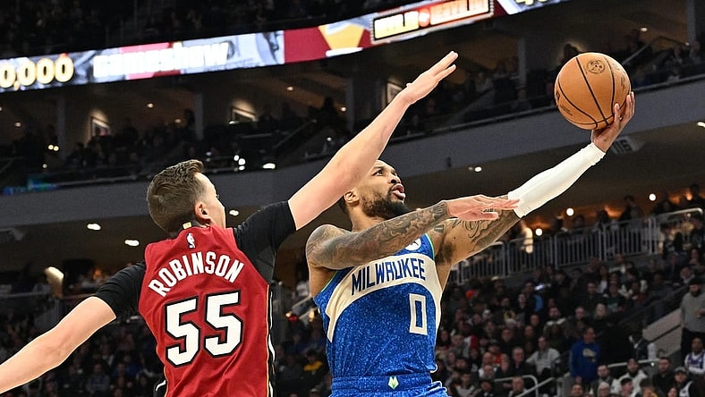 Feb 13, 2024; Milwaukee, Wisconsin, USA; Milwaukee Bucks guard Damian Lillard (0) drives to the basket against Miami Heat forward Duncan Robinson (55) in the first half at Fiserv Forum. Mandatory Credit: Michael McLoone-USA TODAY Sports