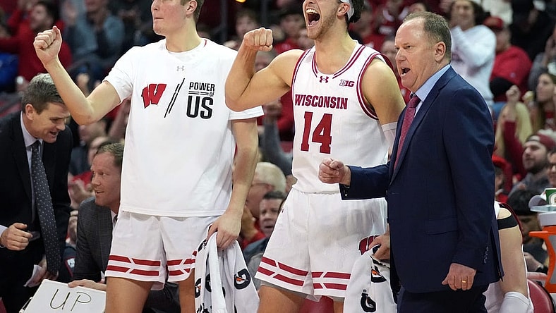 Feb 13, 2024; Madison, Wisconsin, USA;  Wisconsin Badgers forward Nolan Winter (31), forward Carter Gilmore (14) and head coach Greg Gard celebrate a three point basket during the second half against the Ohio State Buckeyes at the Kohl Center. Mandatory Credit: Kayla Wolf-USA TODAY Sports