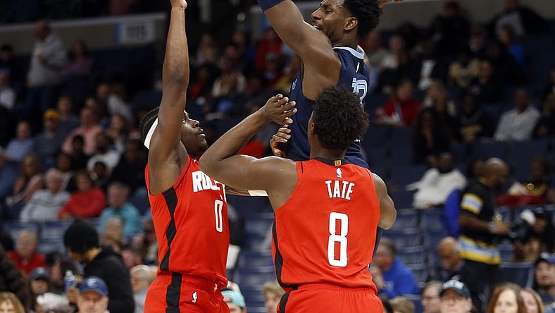 Feb 14, 2024; Memphis, Tennessee, USA; Memphis Grizzlies forward-center Jaren Jackson Jr. (13) passes the ball as Houston Rockets guard Aaron Holiday (0) and forward Jae'Sean Tate (8) defend during the first half at FedExForum. Mandatory Credit: Petre Thomas-USA TODAY Sports