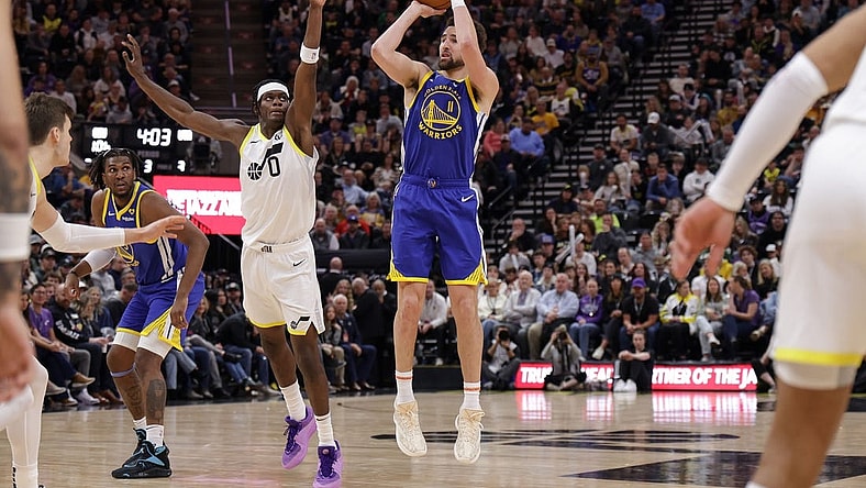 Feb 15, 2024; Salt Lake City, Utah, USA; Golden State Warriors guard Klay Thompson (11) shoots as Utah Jazz forward Taylor Hendricks (0) defends during the second half at Delta Center. Mandatory Credit: Chris Nicoll-USA TODAY Sports