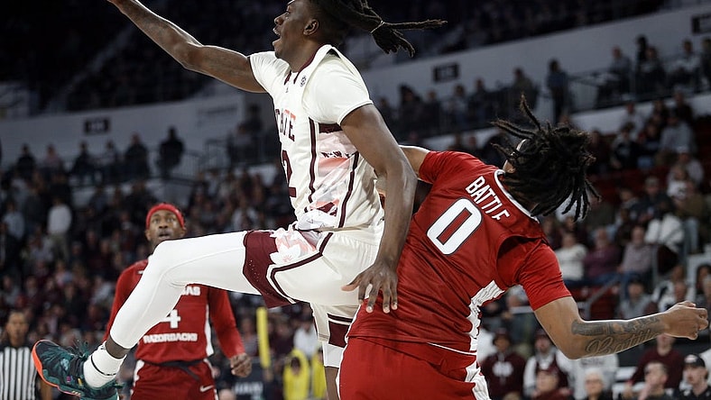 Feb 17, 2024; Starkville, Mississippi, USA; Mississippi State Bulldogs forward KeShawn Murphy (12) collects a rebound over Arkansas Razorbacks guard Khalif Battle (0) during the first half at Humphrey Coliseum. Mandatory Credit: Petre Thomas-USA TODAY Sports