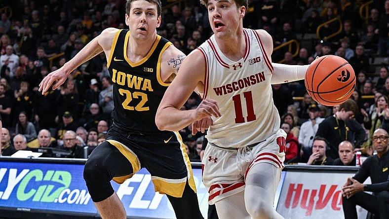 Feb 17, 2024; Iowa City, Iowa, USA; Wisconsin Badgers guard Max Klesmit (11) goes to the basket as Iowa Hawkeyes forward Patrick McCaffery (22) defends during the first half at Carver-Hawkeye Arena. Mandatory Credit: Jeffrey Becker-USA TODAY Sports