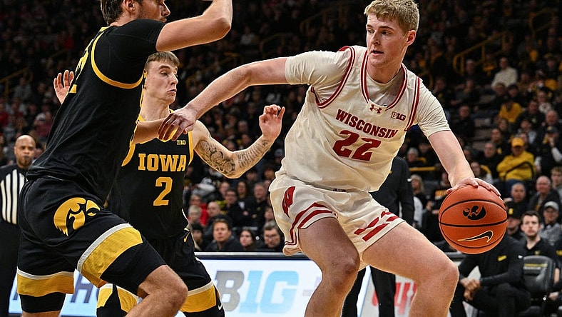 Feb 17, 2024; Iowa City, Iowa, USA; Wisconsin Badgers forward Steven Crowl (22) controls the ball as Iowa Hawkeyes forward Owen Freeman (32) and guard Brock Harding (2) defend during the first half at Carver-Hawkeye Arena. Mandatory Credit: Jeffrey Becker-USA TODAY Sports