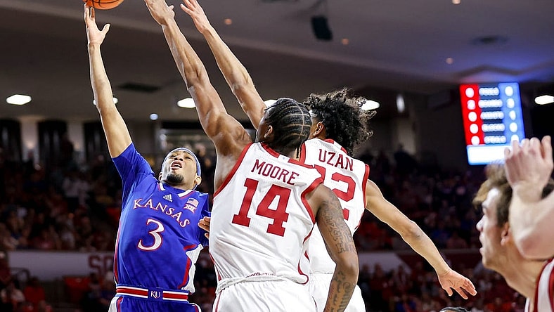 Kansas guard Dajuan Harris Jr. (3) lays up the ball past Oklahoma guard Milos Uzan (12) and Oklahoma forward Jalon Moore (14) in the first half during an NCAA basketball game between The University of Oklahoma (OU) and The University of Kansas (KU), at the Lloyd Noble Center in Norman Okla., on Saturday, Feb. 17, 2024.