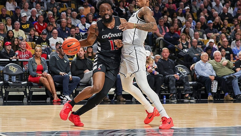 Feb 17, 2024; Orlando, Florida, USA; Cincinnati Bearcats forward John Newman III (15) drives around UCF Knights guard Antwann Jones (1) during the first half at Addition Financial Arena. Mandatory Credit: Mike Watters-USA TODAY Sports
