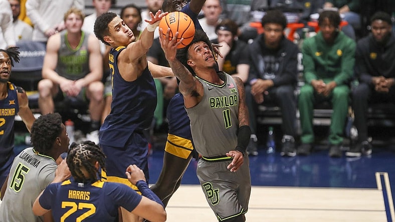 Feb 17, 2024; Morgantown, West Virginia, USA; Baylor Bears forward Jalen Bridges (11) shoots in the lane against West Virginia Mountaineers center Jesse Edwards (7) during the second half at WVU Coliseum. Mandatory Credit: Ben Queen-USA TODAY Sports