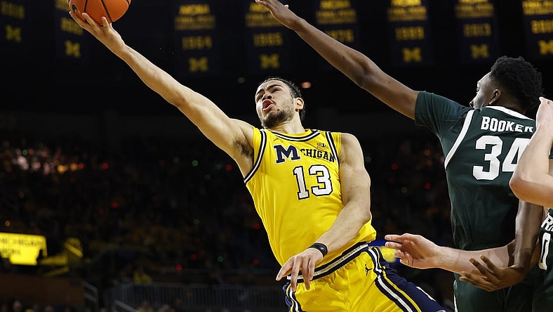 Feb 17, 2024; Ann Arbor, Michigan, USA; Michigan Wolverines forward Olivier Nkamhoua (13) shoots on Michigan State Spartans forward Xavier Booker (34) in the first half  at Crisler Center. Mandatory Credit: Rick Osentoski-USA TODAY Sports