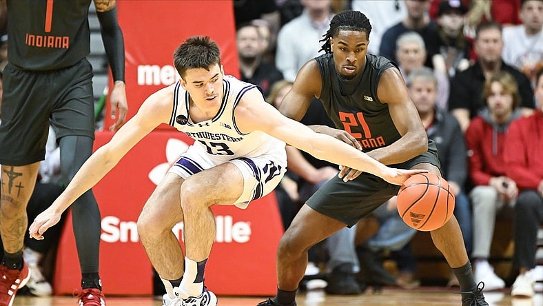 Feb 18, 2024; Bloomington, Indiana, USA;  Northwestern Wildcats guard Brooks Barnhizer (13) reaches for the ball in front of Indiana Hoosiers forward Mackenzie Mgbako (21) during the first half at Simon Skjodt Assembly Hall. Mandatory Credit: Robert Goddin-USA TODAY Sports