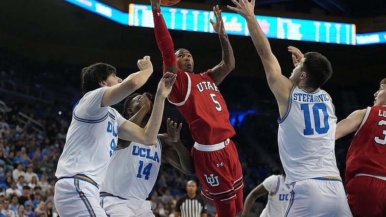 Feb 18, 2024; Los Angeles, California, USA; Utah Utes guard Deivon Smith (5) shoots the ball against forward Kenneth Nwuba (14) and guard Lazar Stefanovic (10) in the first half at Pauley Pavilion presented by Wescom. Mandatory Credit: Kirby Lee-USA TODAY Sports