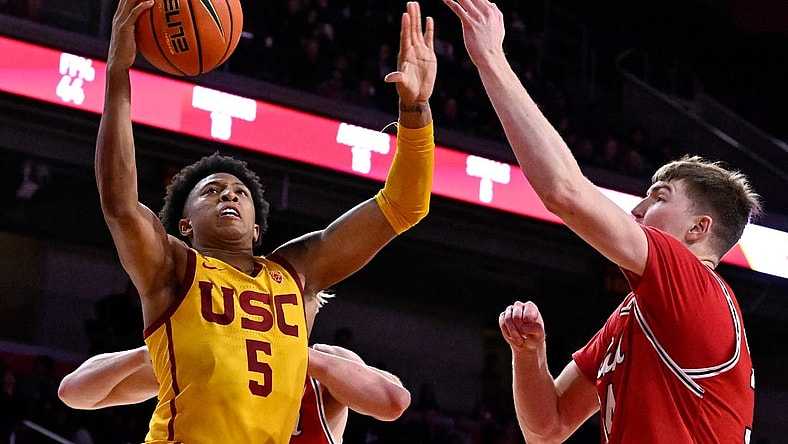 Feb 15, 2024; Los Angeles, California, USA; Southern California Trojans guard Boogie Ellis (5) shoots against Utah Utes center Lawson Lovering (right) during the second half at Galen Center. Mandatory Credit: Alex Gallardo-USA TODAY Sports