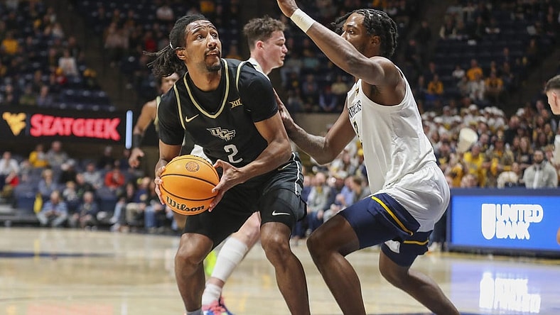 Feb 20, 2024; Morgantown, West Virginia, USA; UCF Knights guard Shemarri Allen (2) shoots against West Virginia Mountaineers guard Kobe Johnson (2) during the first half at WVU Coliseum. Mandatory Credit: Ben Queen-USA TODAY Sports
