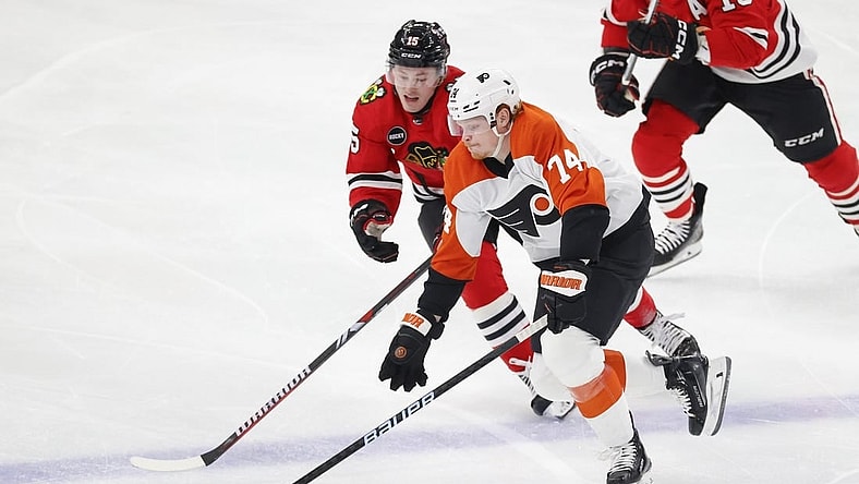 Feb 21, 2024; Chicago, Illinois, USA; Chicago Blackhawks right wing Joey Anderson (15) defends against Philadelphia Flyers right wing Owen Tippett (74) during the second period at United Center. Mandatory Credit: Kamil Krzaczynski-USA TODAY Sports