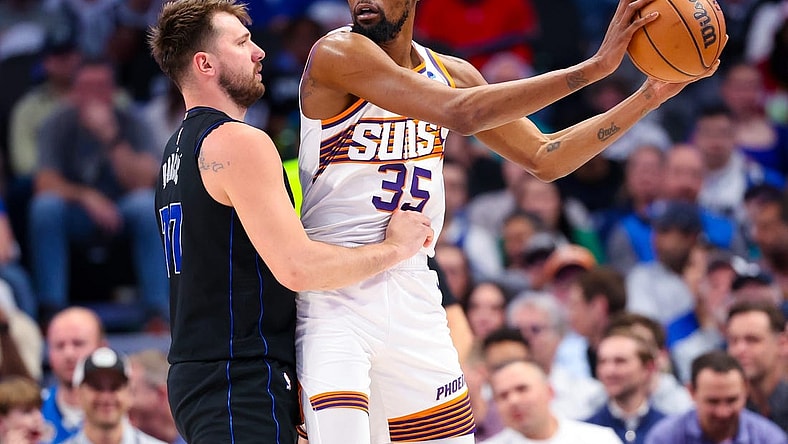 Feb 22, 2024; Dallas, Texas, USA;  Phoenix Suns forward Kevin Durant (35) controls the ball as Dallas Mavericks guard Luka Doncic (77) defends during the first half at American Airlines Center. Mandatory Credit: Kevin Jairaj-USA TODAY Sports