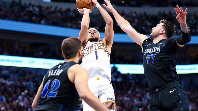 Feb 22, 2024; Dallas, Texas, USA; Phoenix Suns guard Devin Booker (1) shoots over Dallas Mavericks guard Luka Doncic (77) and Dallas Mavericks forward Maxi Kleber (42) during the second half at American Airlines Center. Mandatory Credit: Kevin Jairaj-USA TODAY Sports