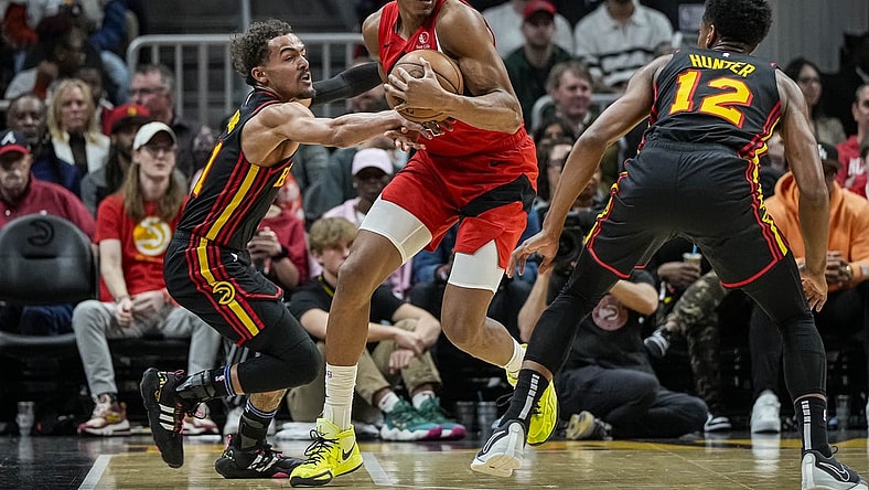 Feb 23, 2024; Atlanta, Georgia, USA; Toronto Raptors forward Scottie Barnes (4) holds the ball defended by Atlanta Hawks guard Trae Young (11) during the first half at State Farm Arena. Mandatory Credit: Dale Zanine-USA TODAY Sports