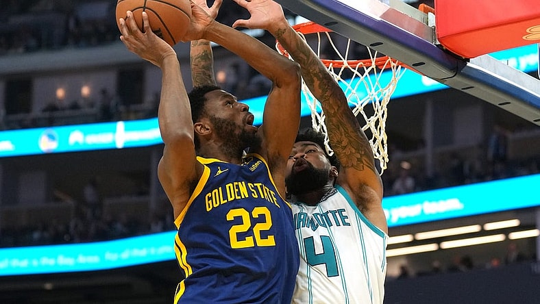 Feb 23, 2024; San Francisco, California, USA; Golden State Warriors forward Andrew Wiggins (22) shoots against Charlotte Hornets center Nick Richards (4) during the second quarter at Chase Center. Mandatory Credit: Darren Yamashita-USA TODAY Sports