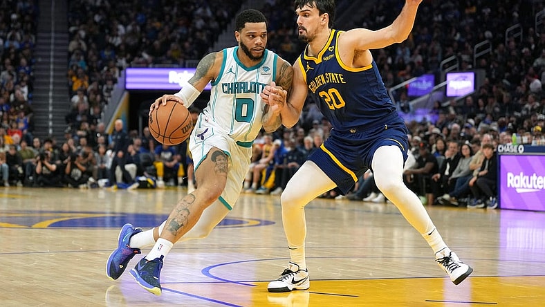 Feb 23, 2024; San Francisco, California, USA; Charlotte Hornets forward Miles Bridges (0) dribbles against Golden State Warriors forward Dario Saric (20) during the fourth quarter at Chase Center. Mandatory Credit: Darren Yamashita-USA TODAY Sports