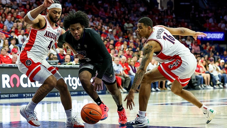 Feb 24, 2024; Tucson, Arizona, USA; Washington Huskies guard Sahvir Wheeler (5) drives to the basket against Arizona Wildcats guard Kylan Boswell (4) and forward Keshad Johnson (16) during the first half at McKale Center. Mandatory Credit: Zachary BonDurant-USA TODAY Sports