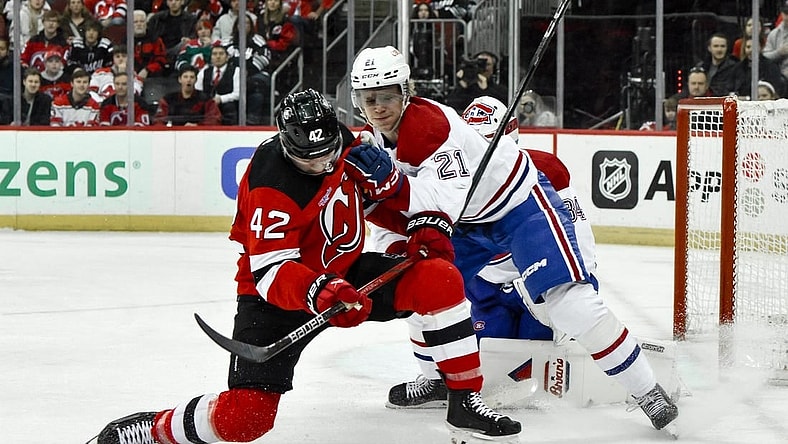 Feb 24, 2024; Newark, New Jersey, USA; New Jersey Devils center Curtis Lazar (42) skates with the puck while being defended by Montreal Canadiens defenseman Kaiden Guhle (21) during the second period at Prudential Center. Mandatory Credit: John Jones-USA TODAY Sports