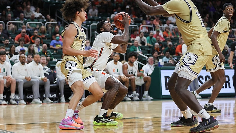 Feb 24, 2024; Coral Gables, Florida, USA; Miami Hurricanes guard Bensley Joseph (4) fakes a shot against Georgia Tech Yellow Jackets guard Naithan George (2) and forward Baye Ndongo (11) during the second half at Watsco Center. Mandatory Credit: Sam Navarro-USA TODAY Sports