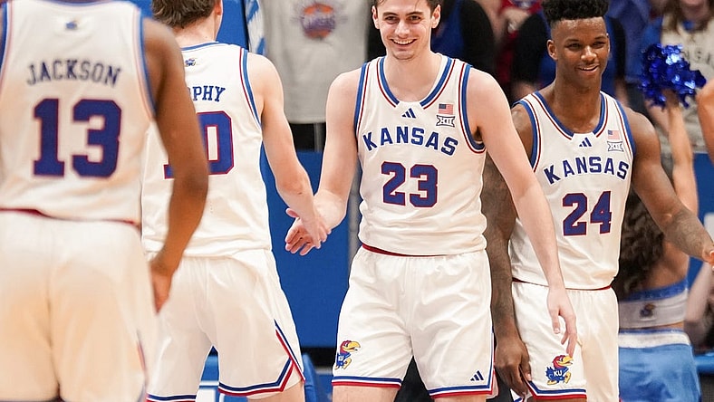 Feb 24, 2024; Lawrence, Kansas, USA; Kansas Jayhawks forward Parker Braun (23) celebrates with guard Johnny Furphy (10) and forward K.J. Adams Jr. (24) after scoring and being fouled by Texas Longhorns during the first half at Allen Fieldhouse. Mandatory Credit: Denny Medley-USA TODAY Sports