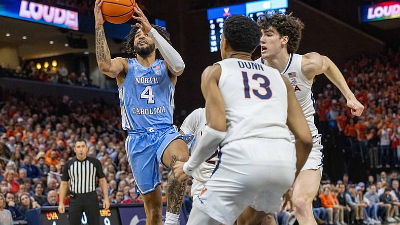 Feb 24, 2024; Charlottesville, Virginia, USA; North Carolina Tar Heels guard RJ Davis (4) attempts a shot while Virginia Cavaliers Ryan Dunn (13) and Blake Buchanan (0) defend him during the first half at John Paul Jones Arena. Mandatory Credit: Hannah Pajewski-USA TODAY Sports
