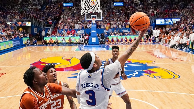 Feb 24, 2024; Lawrence, Kansas, USA; Kansas Jayhawks guard Dajuan Harris Jr. (3) shoots under the basket as Texas Longhorns forward Dillon Mitchell (23) looks on during the second half at Allen Fieldhouse. Mandatory Credit: Denny Medley-USA TODAY Sports