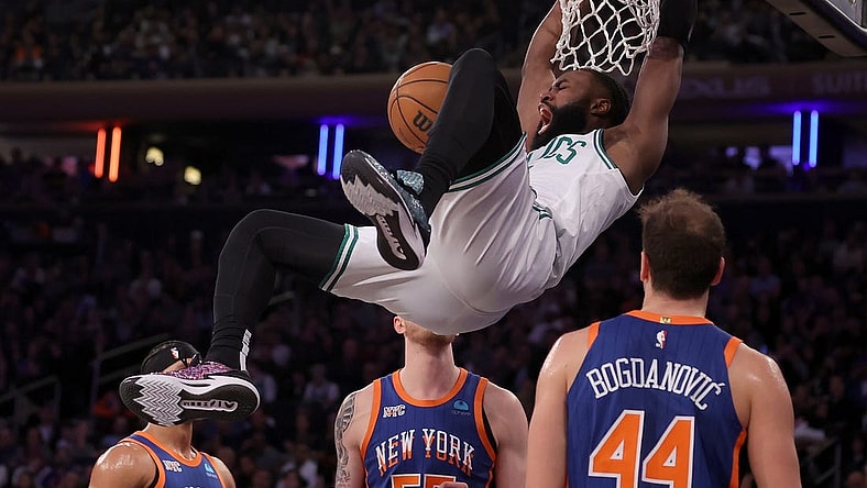 Feb 24, 2024; New York, New York, USA; Boston Celtics guard Jaylen Brown (7) hangs on the rim after a dunk against New York Knicks guard Josh Hart (3) and center Isaiah Hartenstein (55) and forward Bojan Bogdanovic (44) during the second quarter at Madison Square Garden. Mandatory Credit: Brad Penner-USA TODAY Sports