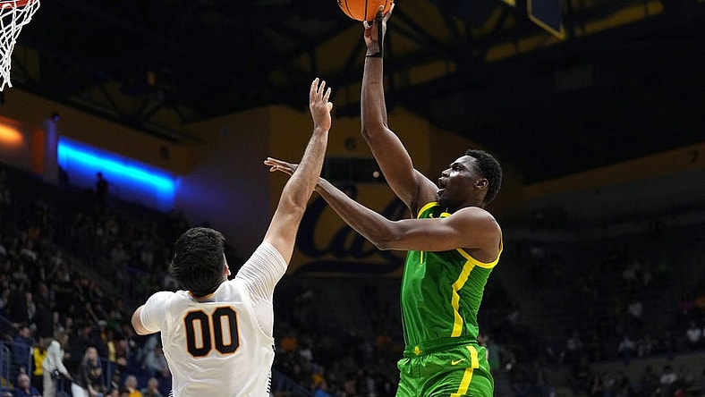 Feb 24, 2024; Berkeley, California, USA; Oregon Ducks center N'Faly Dante (right) shoots against California Golden Bears forward Fardaws Aimaq (00) during the second half at Haas Pavilion. Mandatory Credit: Darren Yamashita-USA TODAY Sports