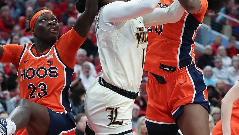 U of L's Merissah Russell (13) gets tied up with Virgina defenders during their game at the KFC Yum! Center in Louisville, Ky. on Feb. 25, 2024.