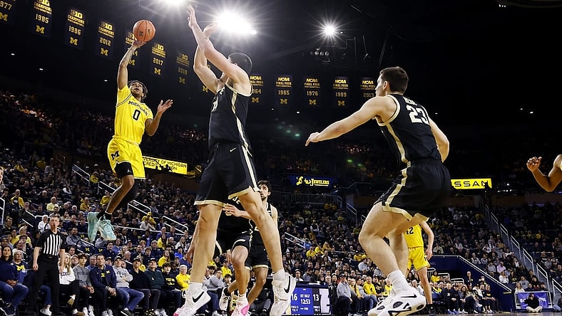 Feb 25, 2024; Ann Arbor, Michigan, USA;  Michigan Wolverines guard Dug McDaniel (0) shoots over Purdue Boilermakers center Zach Edey (15) in the first half at Crisler Center. Mandatory Credit: Rick Osentoski-USA TODAY Sports