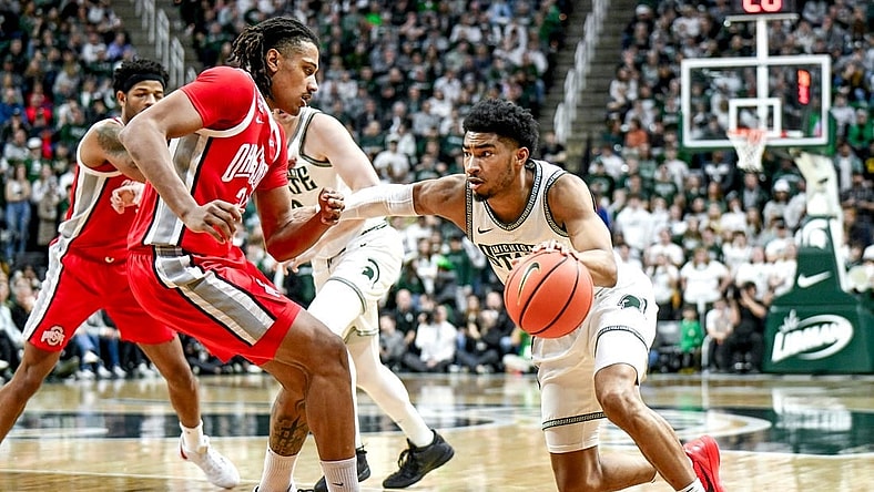 Michigan State's Jaden Akins, right, moves the ball as Ohio State's Devin Royal defends during the first half on Sunday, Feb. 25, 2024, at the Breslin Center in East Lansing.