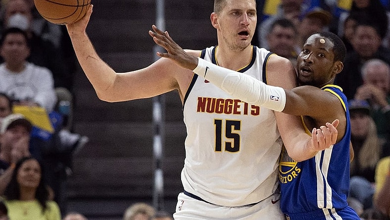 Feb 25, 2024; San Francisco, California, USA; Golden State Warriors forward Jonathan Kuminga (right) harasses Denver Nuggets center Nikola Jokic (15) during the first quarter at Chase Center. Mandatory Credit: D. Ross Cameron-USA TODAY Sports