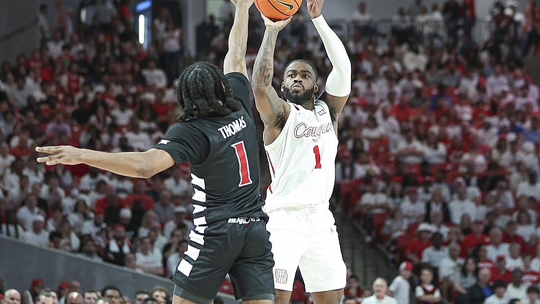 Feb 27, 2024; Houston, Texas, USA; Houston Cougars guard Jamal Shead (1) shoots the ball as Cincinnati Bearcats guard Day Day Thomas (1) defends during the first half at Fertitta Center. Mandatory Credit: Troy Taormina-USA TODAY Sports