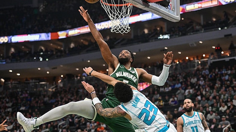 Feb 27, 2024; Milwaukee, Wisconsin, USA;  Milwaukee Bucks guard Malik Beasley (5) takes a shot against Charlotte Hornets guard Tre Mann (23) in the first quarter at Fiserv Forum. Mandatory Credit: Benny Sieu-USA TODAY Sports
