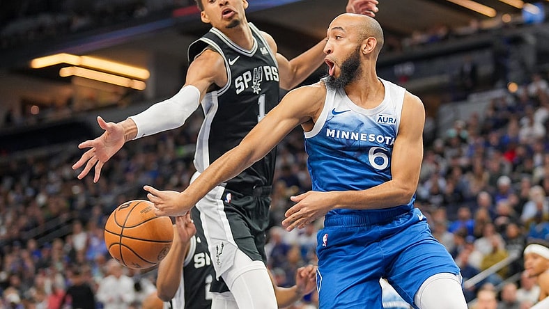 Feb 27, 2024; Minneapolis, Minnesota, USA; Minnesota Timberwolves guard Jordan McLaughlin (6) passes against the San Antonio Spurs center Victor Wembanyama (1) in the second quarter at Target Center. Mandatory Credit: Brad Rempel-USA TODAY Sports