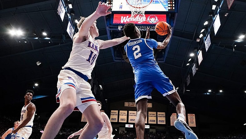 Feb 27, 2024; Lawrence, Kansas, USA; Brigham Young Cougars guard Jaxson Robinson (2) shoots as Kansas Jayhawks guard Johnny Furphy (10) defends during the second half at Allen Fieldhouse. Mandatory Credit: Denny Medley-USA TODAY Sports