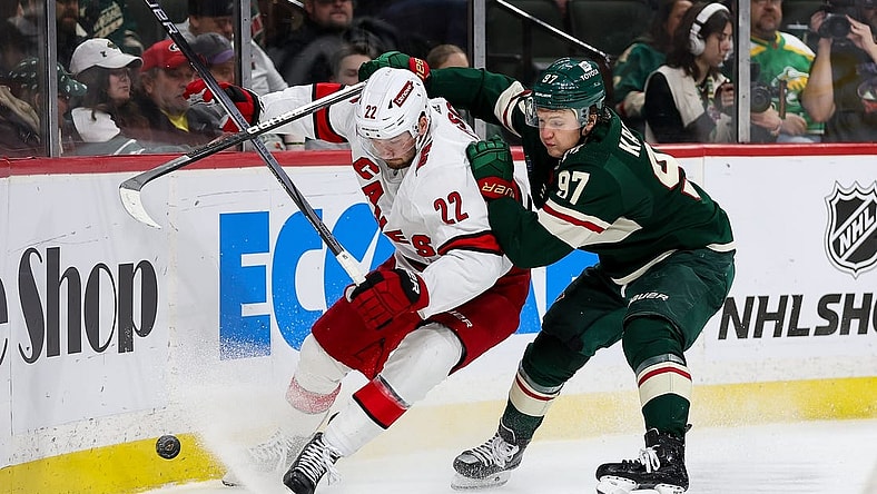 Feb 27, 2024; Saint Paul, Minnesota, USA; Carolina Hurricanes defenseman Brett Pesce (22) and Minnesota Wild left wing Kirill Kaprizov (97) compete for the puck during the second period at Xcel Energy Center. Mandatory Credit: Matt Krohn-USA TODAY Sports