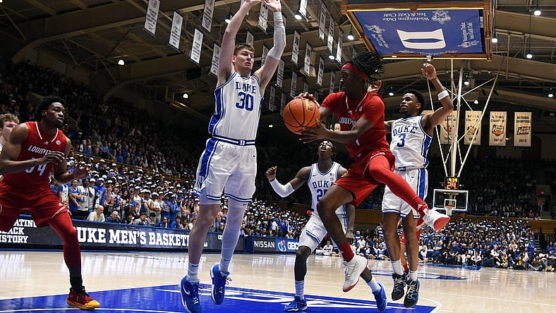Feb 28, 2024; Durham, North Carolina, USA; Louisville Cardinals guard Ty-Laur Johnson (4) throws a pass around Duke Blue Devils center Kyle Filipowski (30) during the first half at Cameron Indoor Stadium. Mandatory Credit: Rob Kinnan-USA TODAY Sports